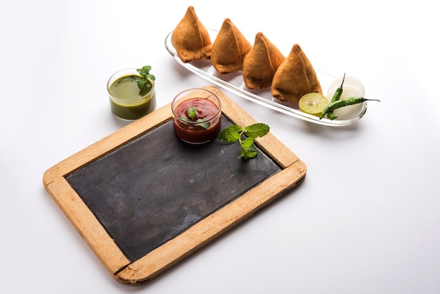 Snack Samosa servido con salsa de tomate y chutney de menta