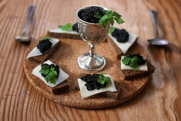 Snack schwarzer Kaviar auf einem hölzernen braunen Hintergrund