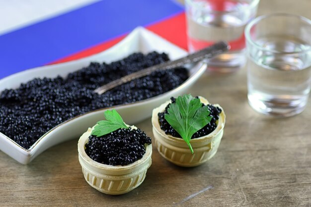 Snack tradicional ruso caviar negro sobre un fondo de madera