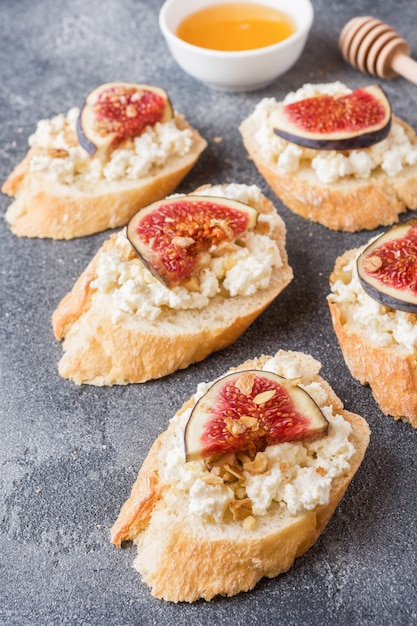 Snacks Bruschetta mit Hüttenkäse, Walnuss und Honig und Feigen