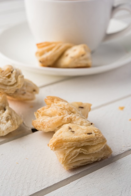 Snacks de massa folhada indianos ou khari ou salgados, servidos com chá quente indiano, textura de foco seletivo