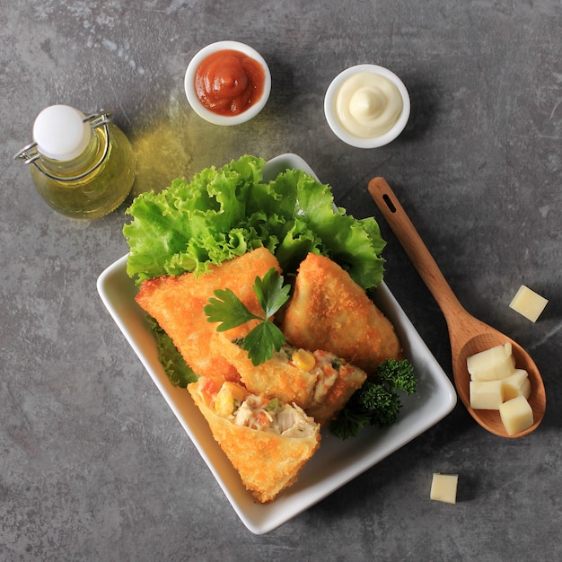 Snacks indonésios: Risoles fritos ou vegetais Risol com carne picada. Servido com Molho de Pimenta e Maionese, Enfeite com Salsa Fresca.