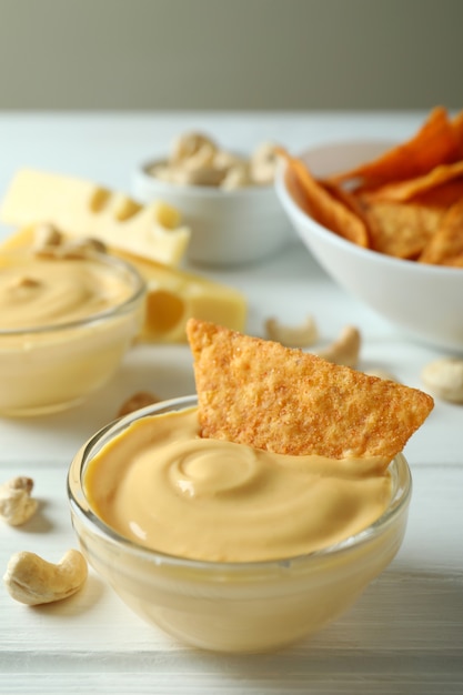 Snacks mit Käsesauce auf weißem Holztisch