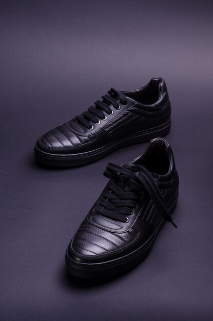 Sneakers de couro genuíno à moda sobre um fundo preto Foto de calçado à moda