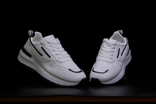 Sneakers esportivos brancos sobre fundo preto