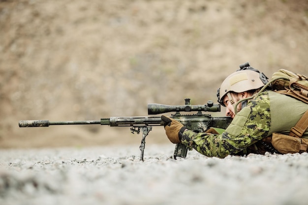 Sniper camuflado com arma de atirador nas mãos