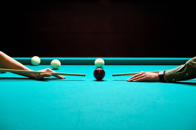 Snooker - close-up de dois homens jogando bilhar, mirando na bola na mesa de bilhar