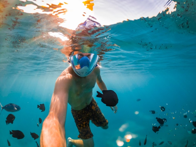 Snorkeling cerca de una isla tropical Joven nada en el agua Vacaciones en el mar