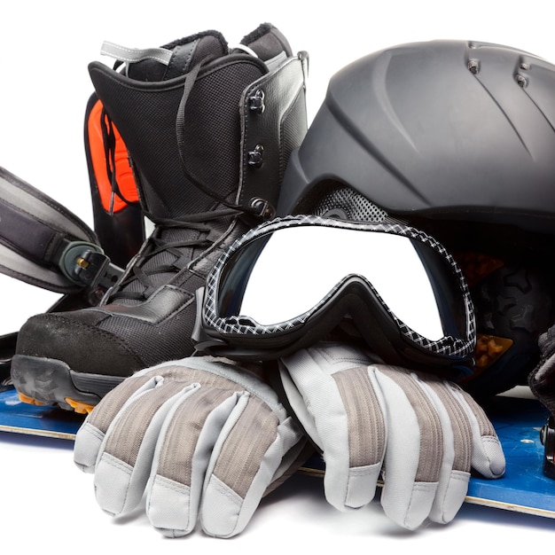 Snowboard con guantes de casco de bota y gafas de protección sobre un fondo blanco