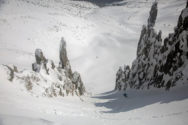 Snowboard en las montañas nevadas entre rocas invierno freeride deporte extremo