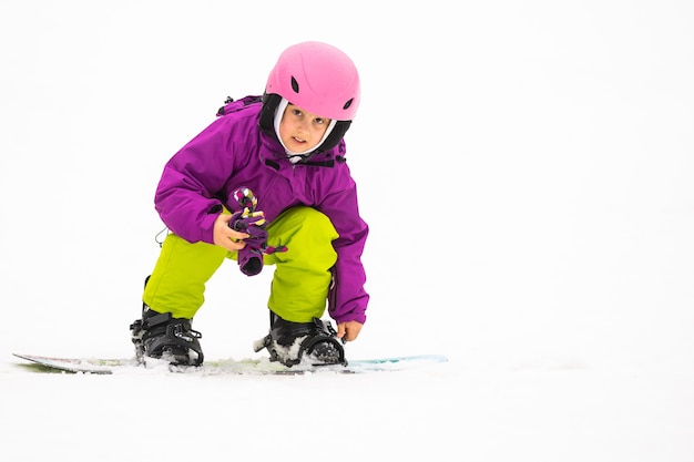 Snowboard winter sport. menina aprendendo a fazer snowboard, vestindo roupas quentes de inverno. fundo de inverno.