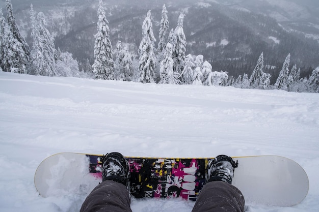 Snowboarder auf dem Hügel, der die Berglandschaft genießt