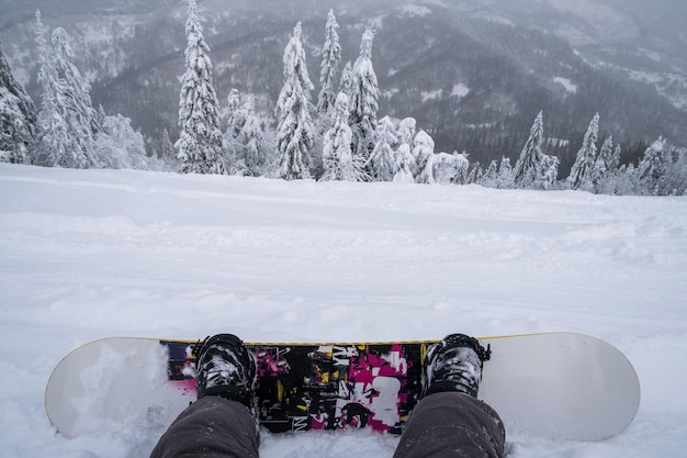 Foto snowboarder auf dem hügel, der die berglandschaft genießt