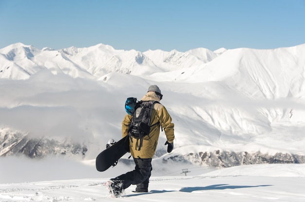 Snowboarder auf den Winterbergen und dem blauen Himmel.