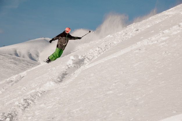 Snowboarder cabalgando por la pendiente con la cámara en las manos en el popular complejo turístico de Gudauri en Georgia