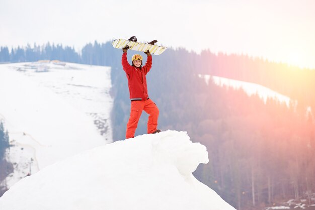 Snowboarder en la cima de la ladera nevada