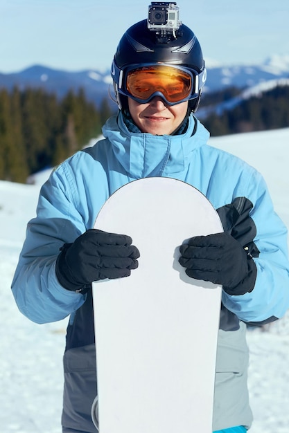 Foto snowboarder com câmera de ação em um capacete óculos de esqui com o reflexo das montanhas nevadas
