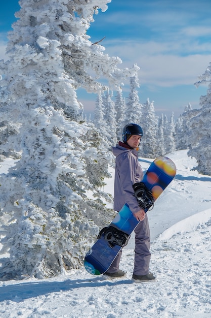Snowboarder com capacete no topo das montanhas