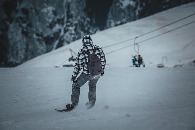 Snowboarder de homem passeios na encosta. estância de esqui.