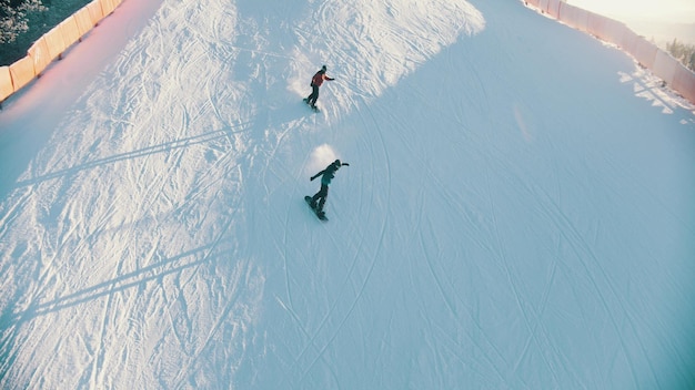 Snowboarder fahren im Freien den Berg hinunter