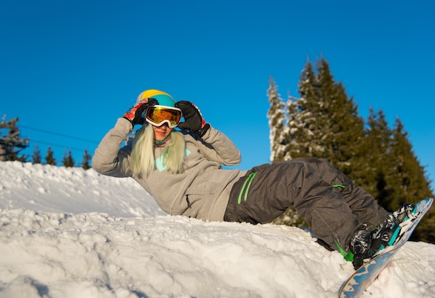 Snowboarder femenino en pendiente en las montañas