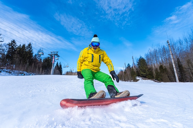 Snowboarder freia na neve em um dia ensolarado