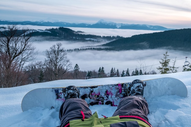 Snowboarder genießen den Blick auf den Sonnenuntergang über den Bergen der Ukraine Karpaten