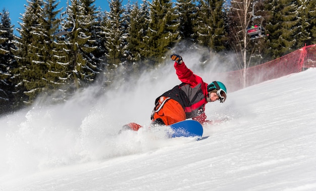 Snowboarder masculino desfrutando de esqui nas montanhas em um dia ensolarado de inverno