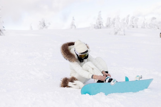 Snowboarder de mujer en las laderas en un día de invierno helado