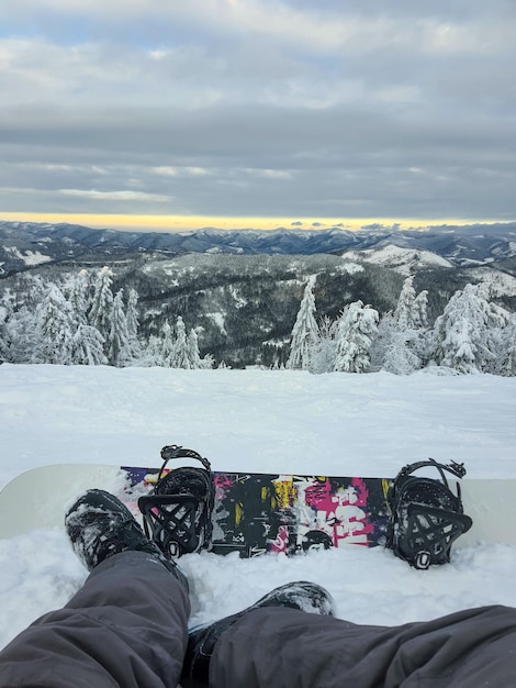 Snowboarder na colina apreciando o ponto de vista da paisagem das montanhas