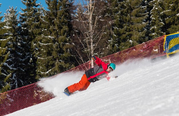 Snowboarder profissional, montando a ladeira nas montanhas.