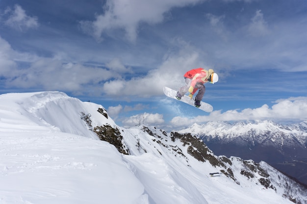 Snowboarder volando en las montañas.