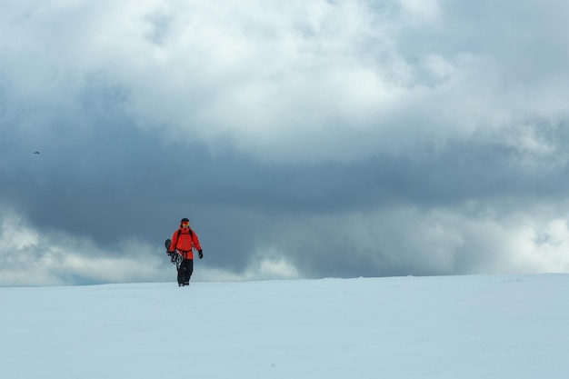 Snowboarders escalam montanhas praticando snowboard