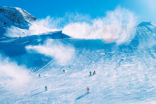 Snowboarders en la estación de esquí Hintertux Glacier en Zillertal en Tirol. Austria en invierno en los Alpes. Gente en las montañas alpinas con nieve. Diversión cuesta abajo. Cielo azul y laderas blancas. Hintertuxer Gletscher.