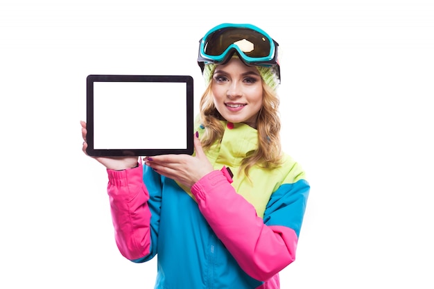 Snowboardmädchen, das Tablette nahe Gesicht hält