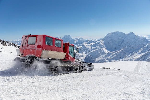 Snowcat en una pendiente en lo alto de las montañas