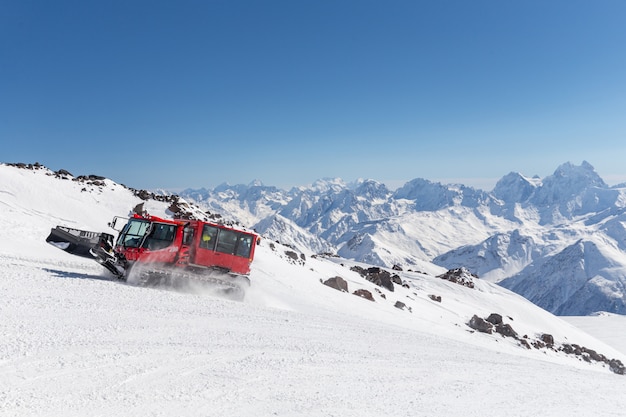 Snowcat en una pendiente en lo alto de las montañas