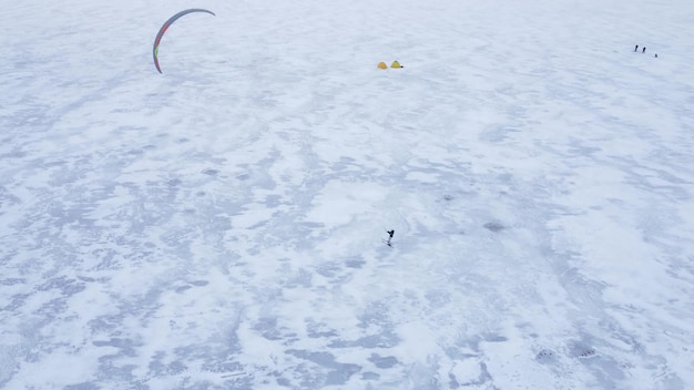 SnowKiting deporte de kitesurf en el lago de hielo invierno Vista aérea de drones