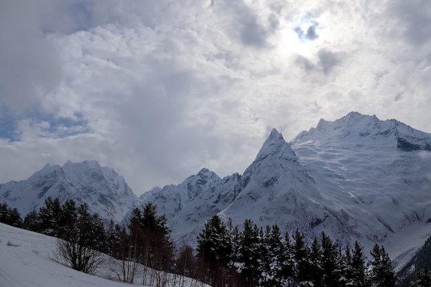 Snowy Mountains Gipfel im blauen Himmel der Wolken Kaukasus