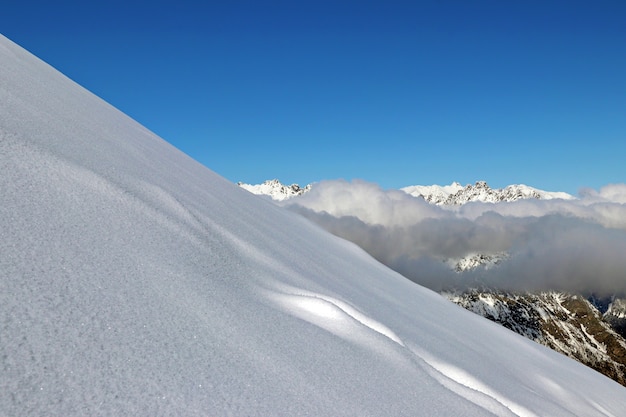 Snowy Mountains Gipfel im blauen Himmel der Wolken Kaukasus