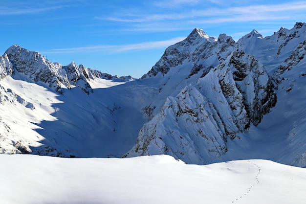 Snowy Mountains Gipfel im blauen Himmel der Wolken Kaukasus