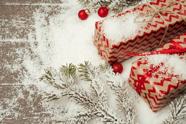 Snowy-Zusammensetzung mit Weihnachtsgeschenk auf Holztisch