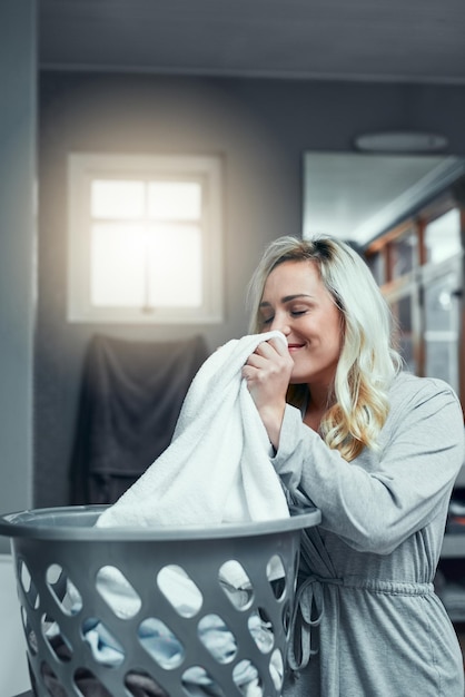 So frisch riechen Aufnahme einer jungen Frau, die zu Hause an frischer und sauberer Wäsche riecht