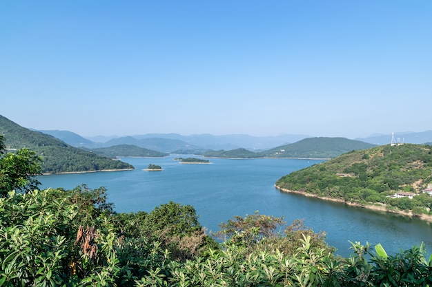 Sob o céu azul, o lago é cercado por montanhas e florestas