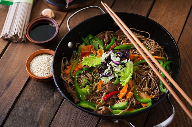 Soba fideos con carne de res zanahorias cebollas y pimientos dulces