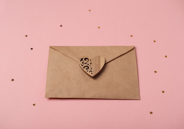 Sobre artesanal con el corazón de madera con estrellitas. Carta de amor romántica por concepto de día de San Valentín.