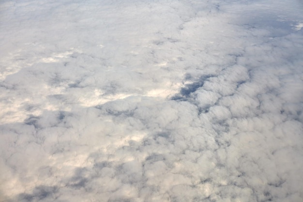 Sobre as nuvens, vista aérea superior da janela da aeronave, nuvens azuis brancas grossas parecem espuma macia