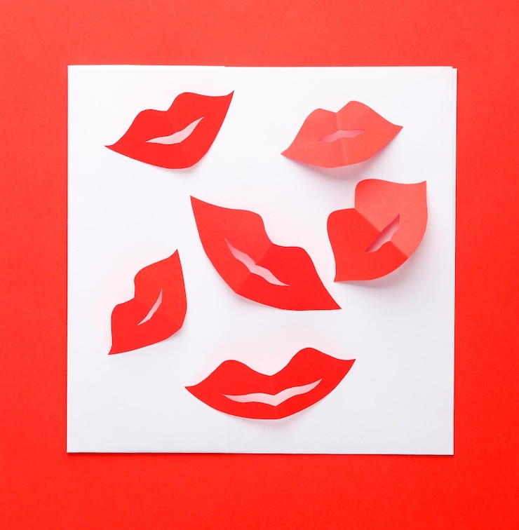 Foto sobre blanco con labios de mujer rojos cortados de papel sobre fondo rojo carta de amor día de san valentín vista superior