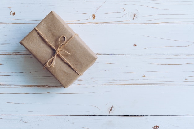 Sobre la caja de regalo marrón en fondo de madera de la tabla con el espacio de la copia.