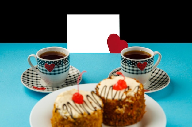 Foto sobre un fondo azul pasteles en un plato y dos tazas de café y una tarjeta con una declaración